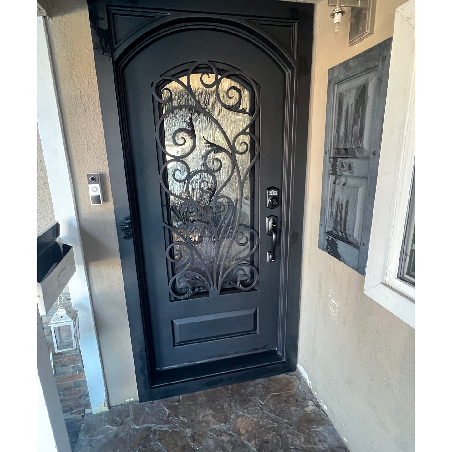 Decorative black door with glass panel in a room with beige walls.