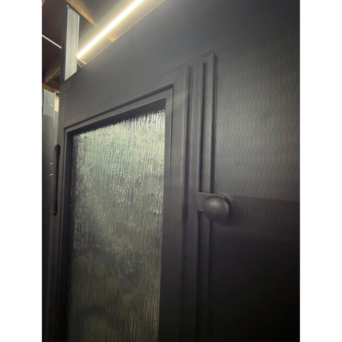 Dark wooden door with glass panel and handle, possibly in a home setting.