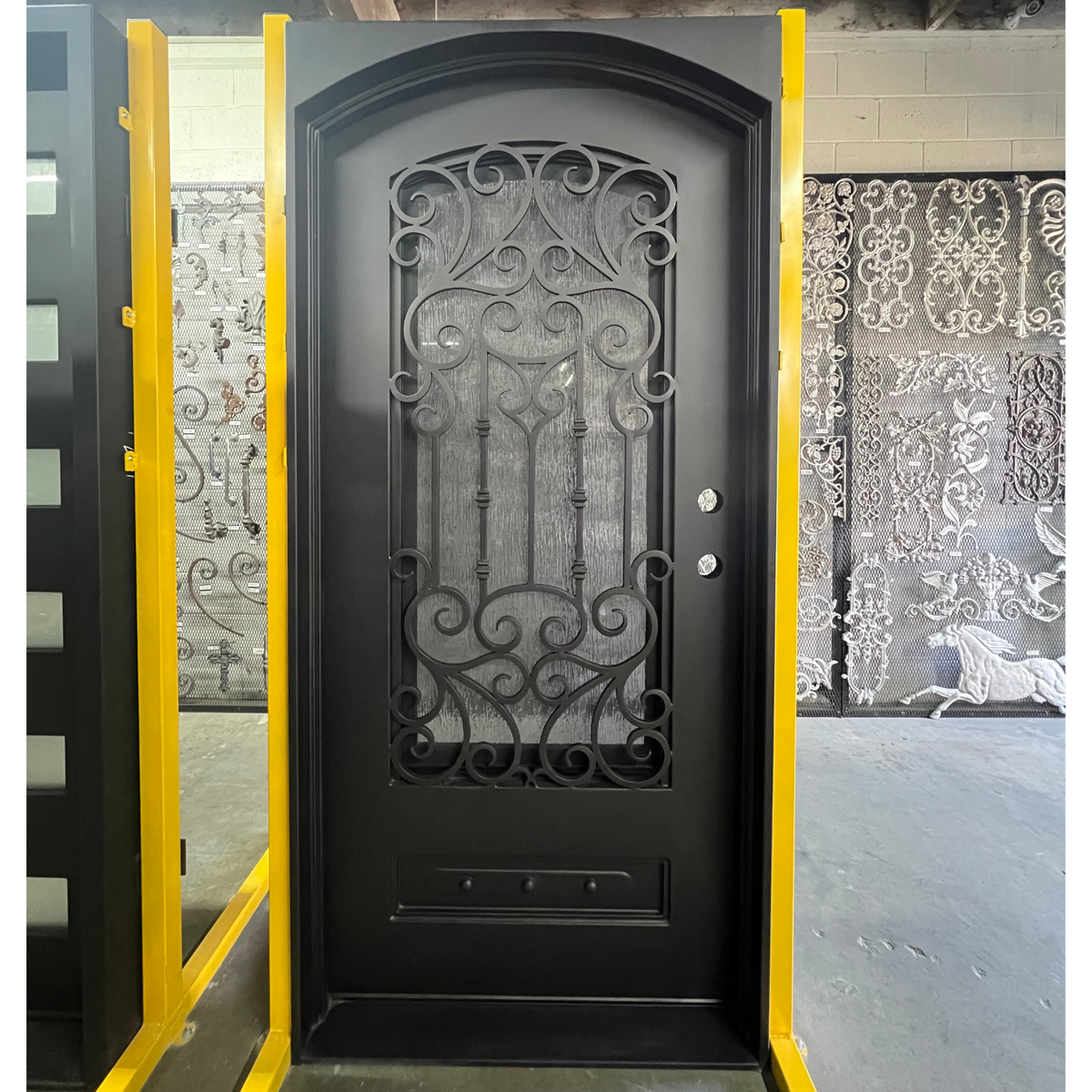 Decorative black door with intricate ironwork in a showroom setting
