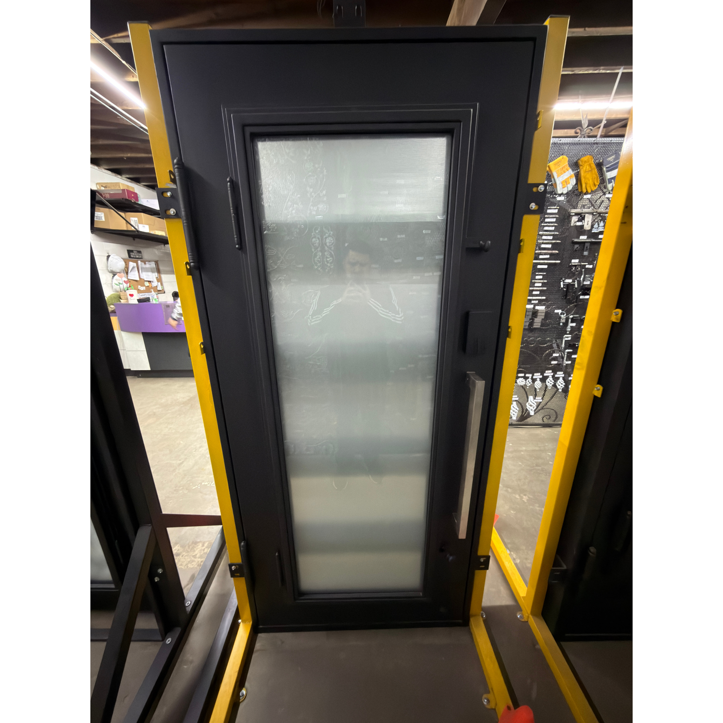 Black door with glass panel on a yellow stand in an indoor setting