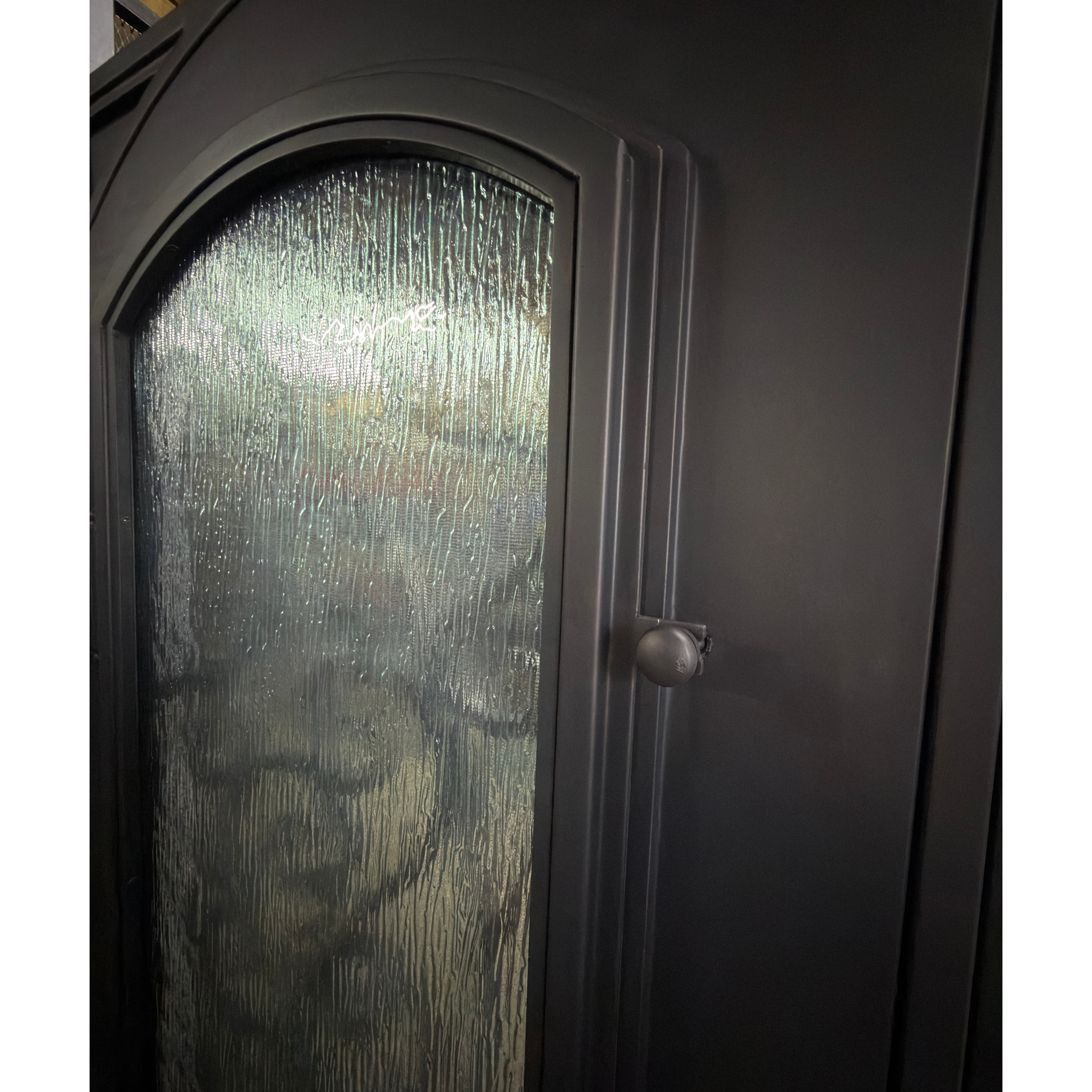 Dark wooden wardrobe with a glass panel and handle