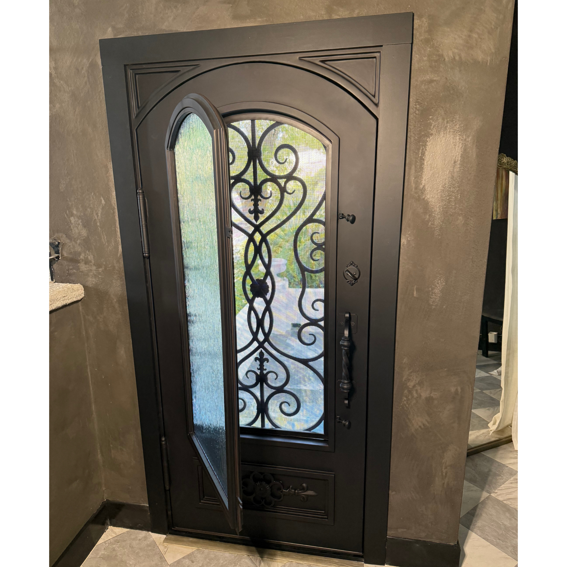 Decorative black iron door with glass panels in a room with beige walls.