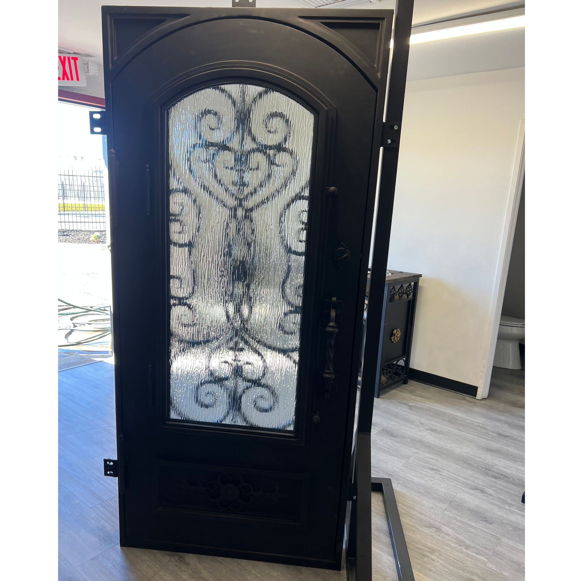 Decorative black door with glass panel in a showroom setting