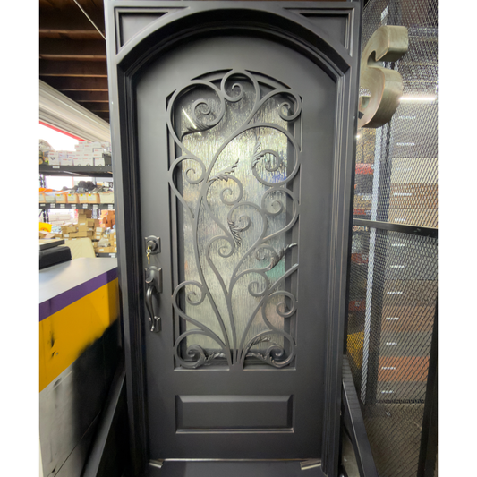 Decorative black door with intricate ironwork in a showroom setting
